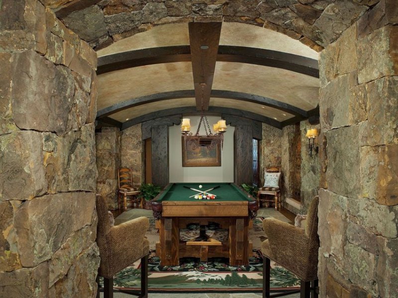 rustic-game-room-with-stone-walls-arched-ceiling-and-pool-table.jpg